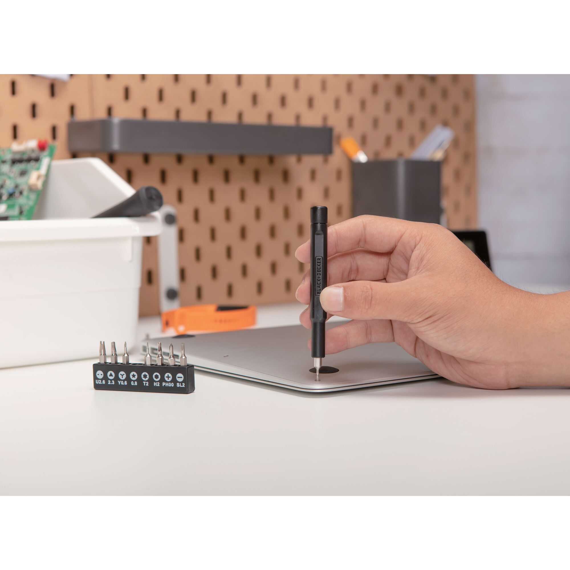 BLACKDECKER BD40K27 precision screwdriver used on laptop cover, close-up photography.