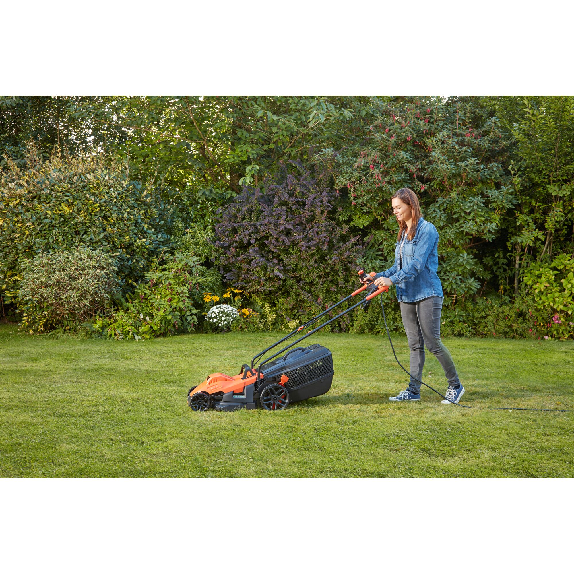 BLACKDECKER BEMW461BH lawn mower in use on grass by person outdoors, orange and black design.