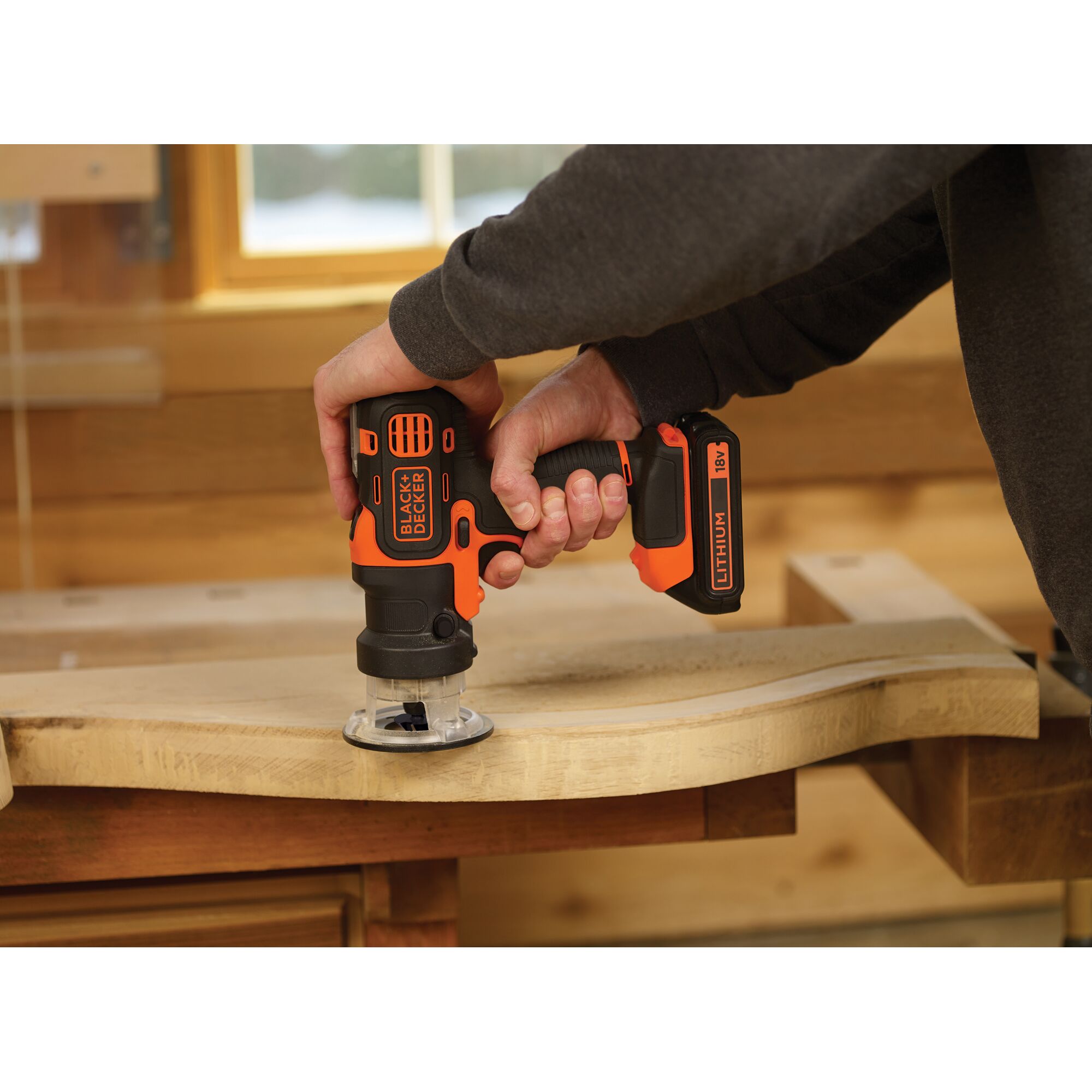 BLACKDECKER MT218K cordless power tool used on wood in workshop, orange-black design.